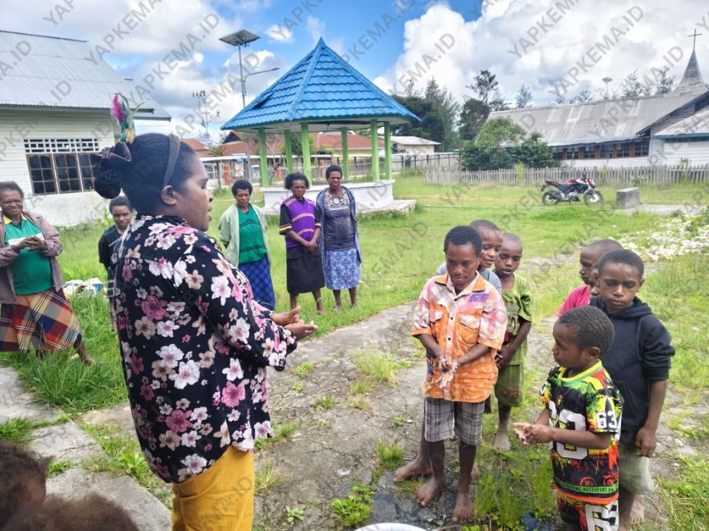 Ibu Naomi Edowai sedang mengajarkan praktek cuci tangan kepada anak-anak (Dok. Yapkema)