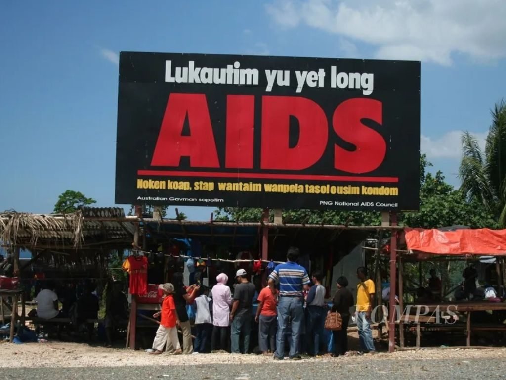 Baliho AIDS menyambut para pendatang di garis perbatasan negara Papua Nugini dengan Kabupaten Jayapura, Papua. Seakan hendak mengingatkan kepada pendatang untuk memakai pelindung agar tidak tertular virus mematikan ini. Persebaran HIV/AIDS di perbatasan kedua negara masih tergolong tinggi, (Dok. Kompas, 12/08/2007).