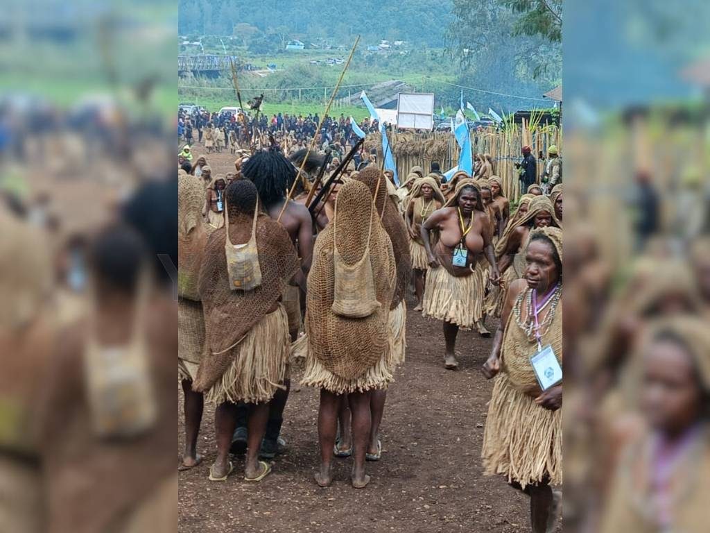 Bagian luar pintu masuk ke Gereja Paroki Kristus Jaya Komopa, banyak hilir mudik peserta dan panitia dengan mayoritas memakai pakaian adat. (Dok. Yapkema)