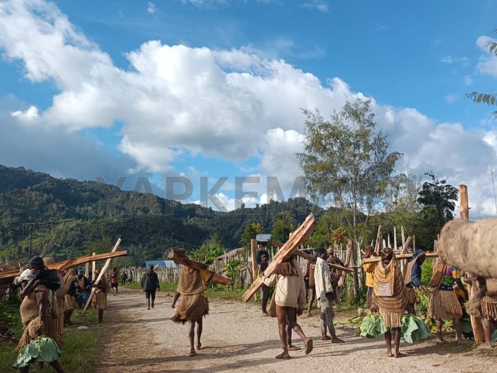 Sebagian umat perwakilan korwil hilir mudik di depan masing-masing Kewita antar sayuran dan kayu bakar sebagai bahan masak bakar batu. (Dok. Yapkema)