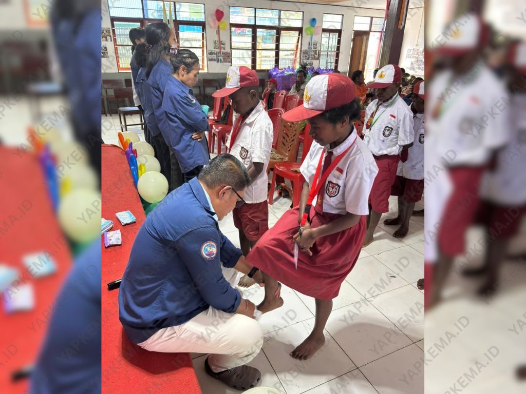 Kepala Sekolah SD Yegeka sedang melakukan proses pembasuhan kaki para siswa. (Dok. Yapkema)