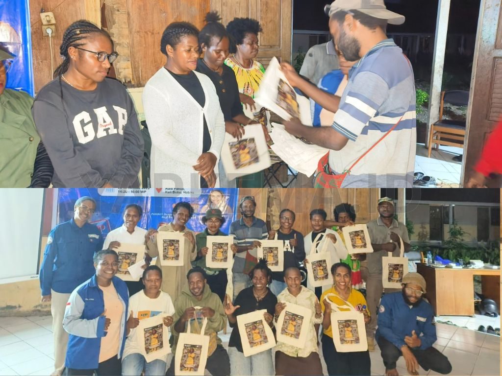 Pimpinan redaksi laolao.org, Mikel Kudiai, membagikan marchandise pada peserta diskusi aktif (Dok. Yapkema).