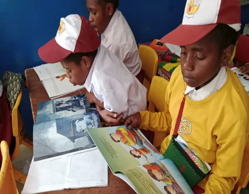 Peserta didik SD Yegeka membaca buku cerita rakyat